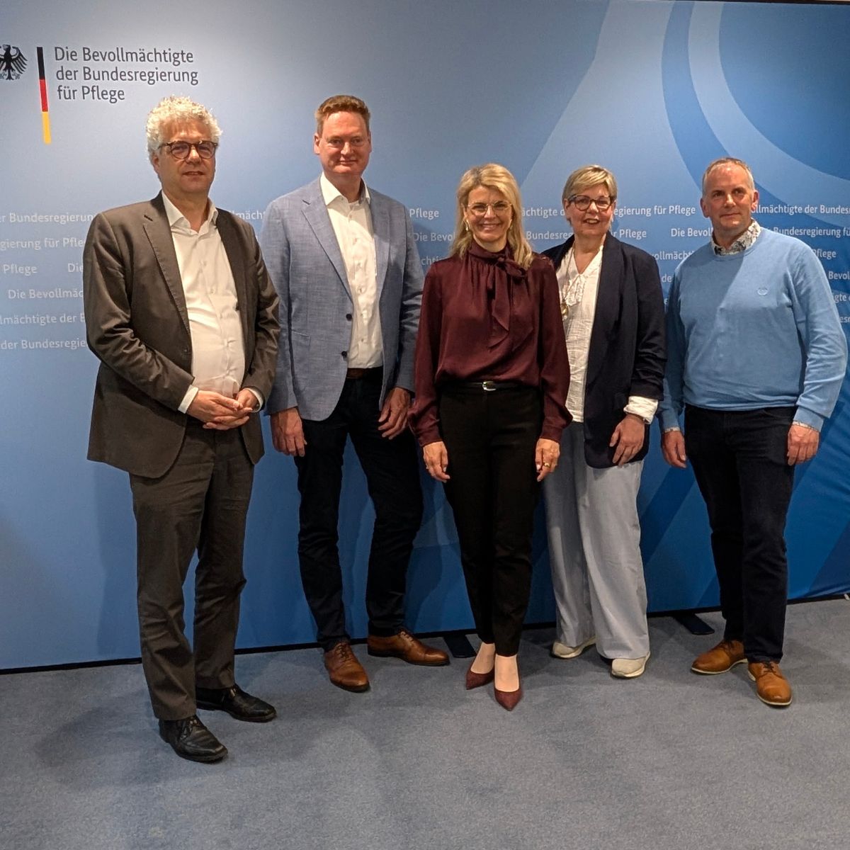 Das Bild zeigt den Vorstand der Starken Pflege gemeinsam mit der Pflegebevollmächtigten Karin Staffler MdB und Stefan Nacke Mdb vor einer blauen Wand mit dem Logo des Ministeriums