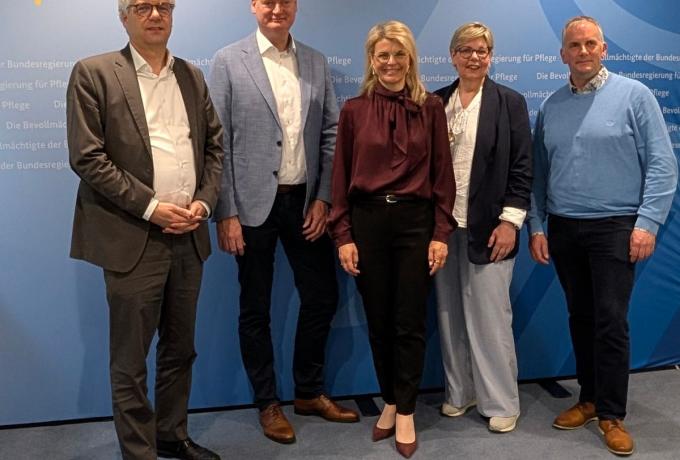 Das Bild zeigt den Vorstand der Starken Pflege gemeinsam mit der Pflegebevollmächtigten Karin Staffler MdB und Stefan Nacke Mdb vor einer blauen Wand mit dem Logo des Ministeriums